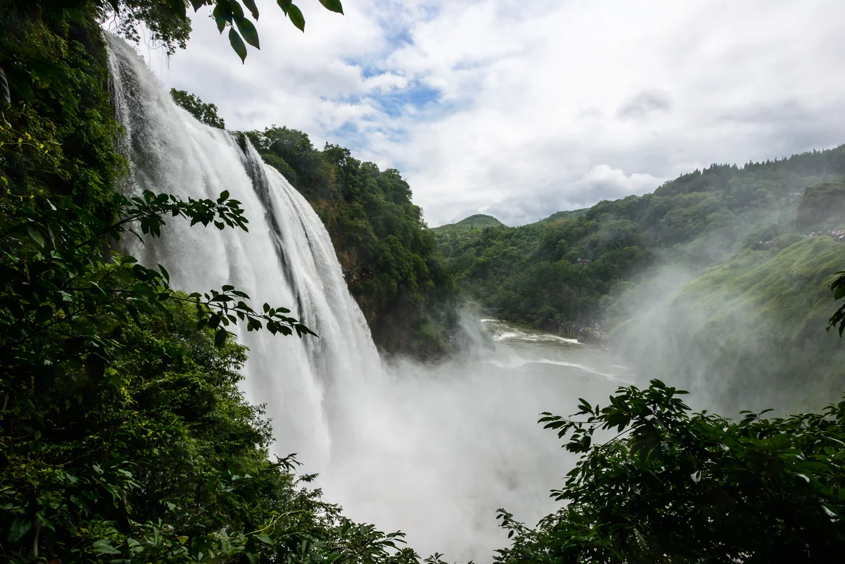 Mist rising from the waterfall base with rainbow effect