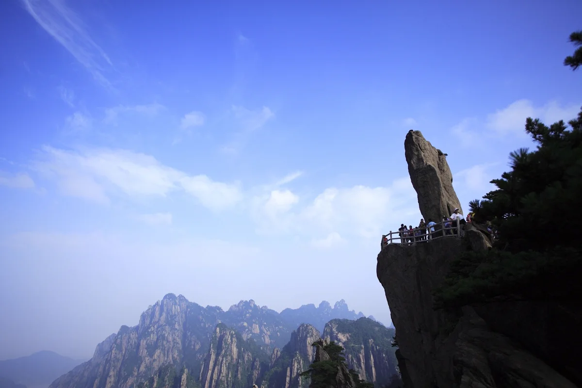 Sea of clouds rolling over Huangshan peaks at dawn with granite spires piercing through