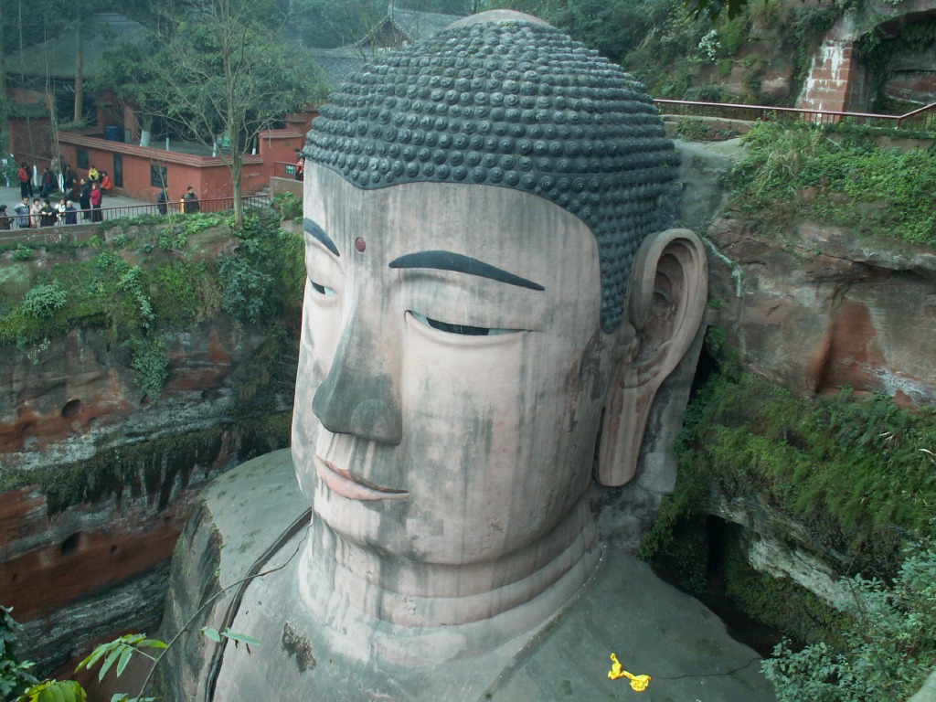 Cliff-side staircase descending past the Buddha