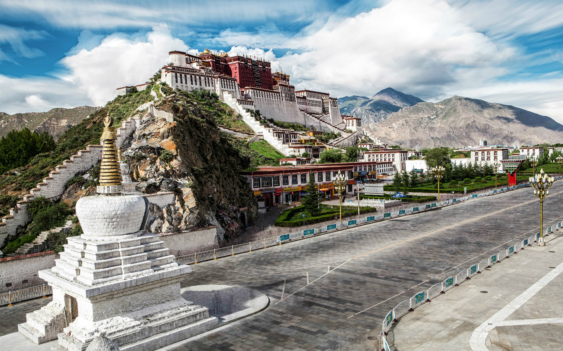 Lhasa city panorama at sunset, golden light bathing the rooftops and mountains