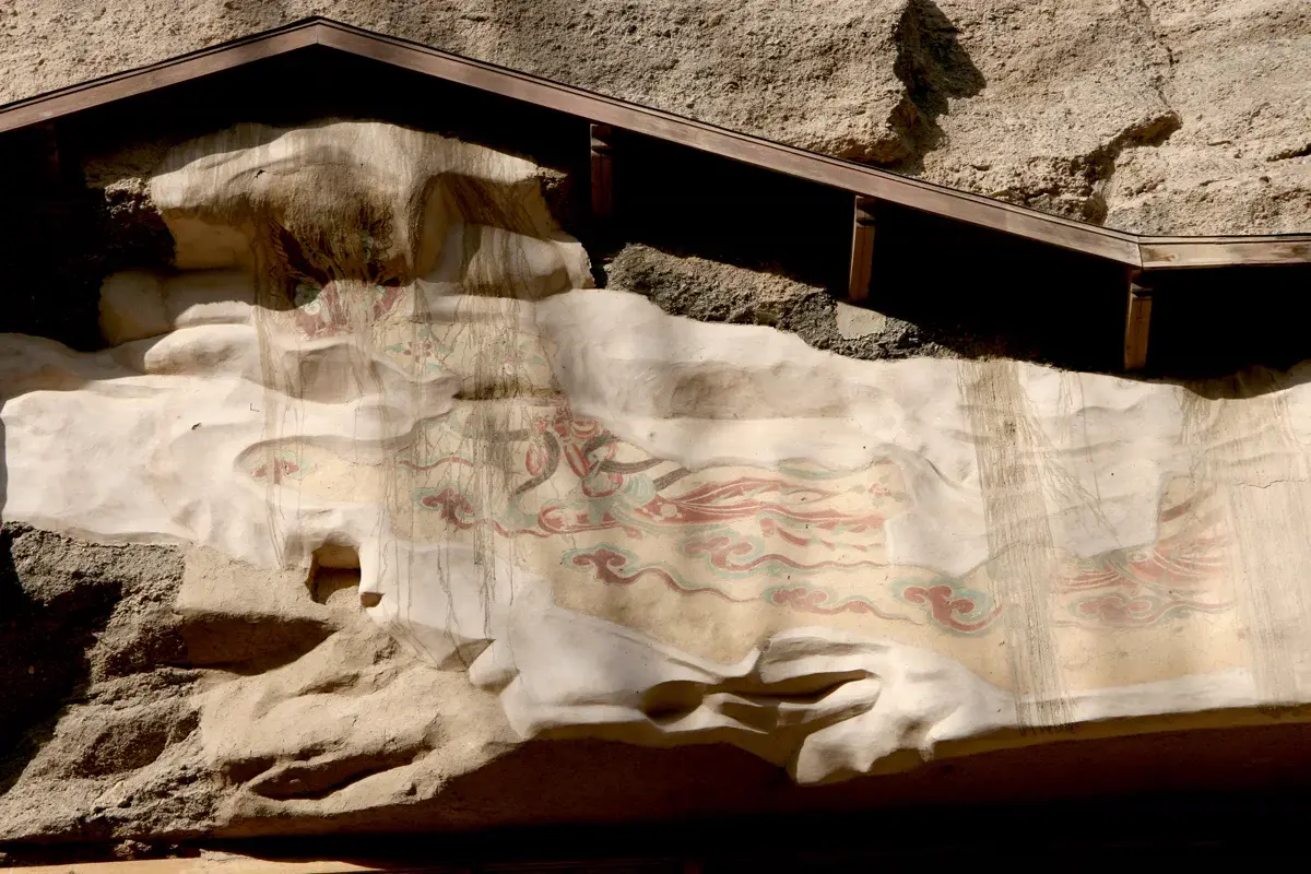 A painted clay figure inside one of the Mogao cave temples, its pigments still vivid after centuries in the dry desert air