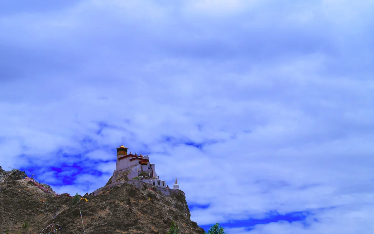 The Potala Palace illuminated at night, its golden roofs glowing above the darkened city of Lhasa