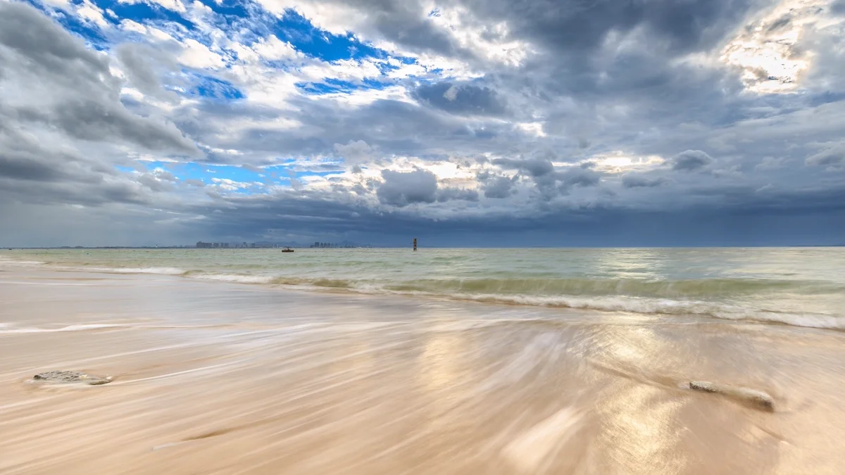 Guanyinshan Beach coastline with waves rolling onto the sand
