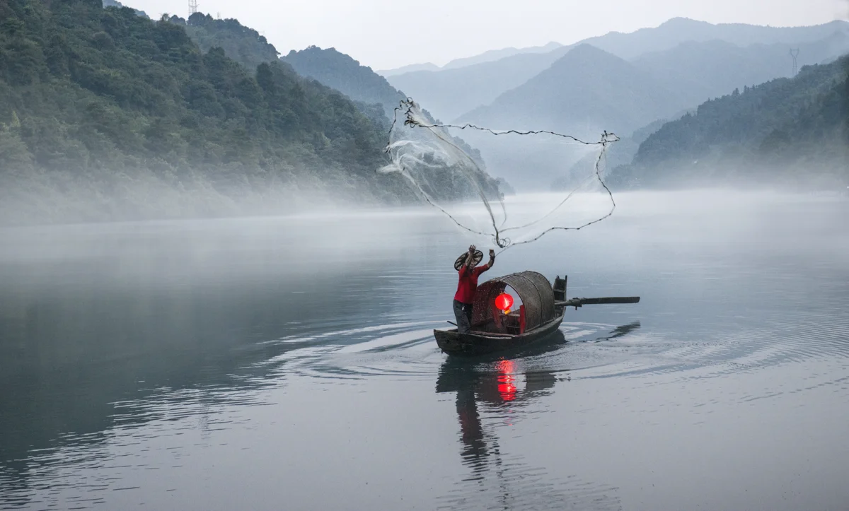 Xiao Dong Jiang morning mist with fisherman casting net